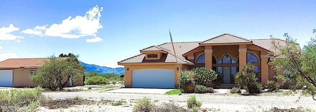 view of front of home with a mountain view and a garage