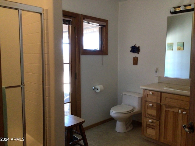 bathroom featuring vanity, toilet, and a shower with door