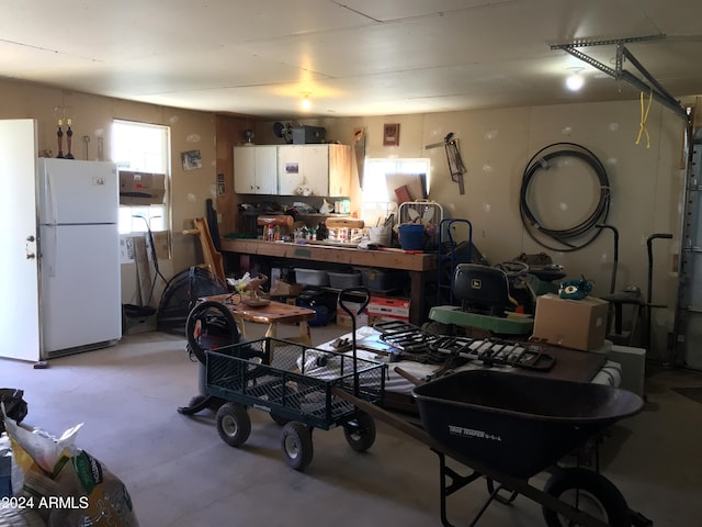 garage with white refrigerator and a workshop area