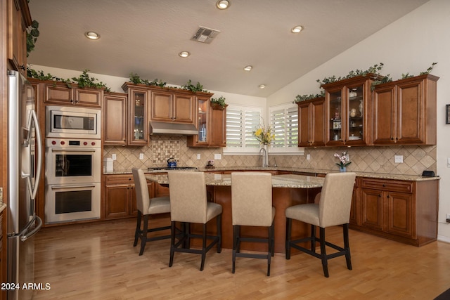 kitchen featuring a breakfast bar, decorative backsplash, and stainless steel appliances