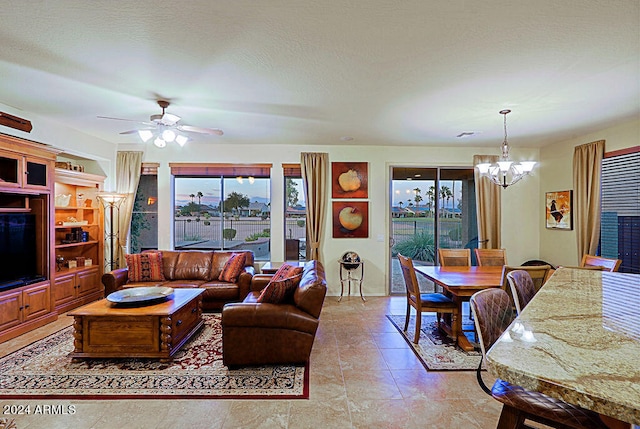 living room with ceiling fan with notable chandelier