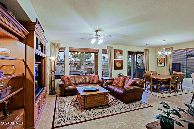 living room with a textured ceiling and ceiling fan with notable chandelier