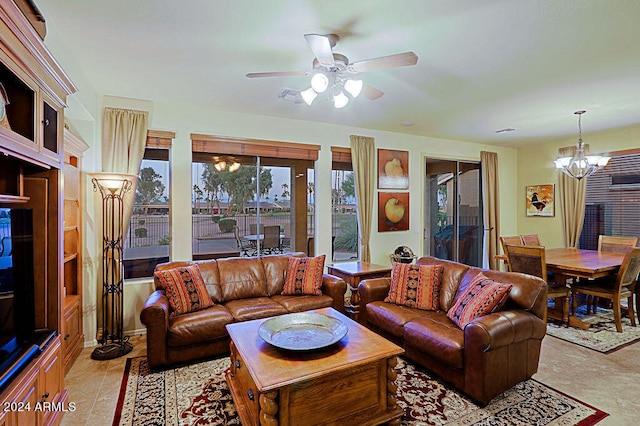 tiled living room featuring ceiling fan with notable chandelier