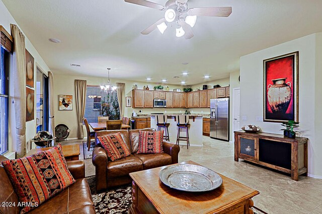 living room with ceiling fan with notable chandelier