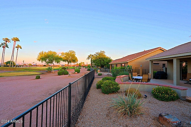 yard at dusk featuring a patio