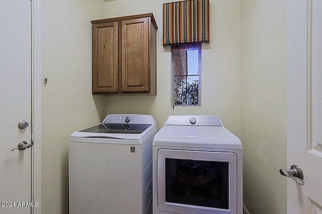 washroom featuring washer and dryer and cabinets