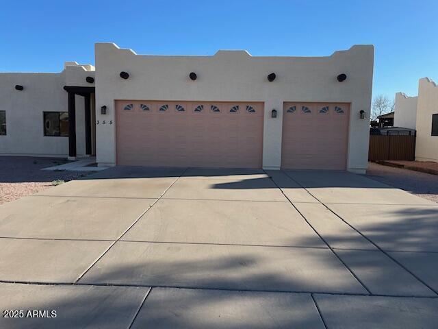 southwest-style home with stucco siding, a garage, and driveway