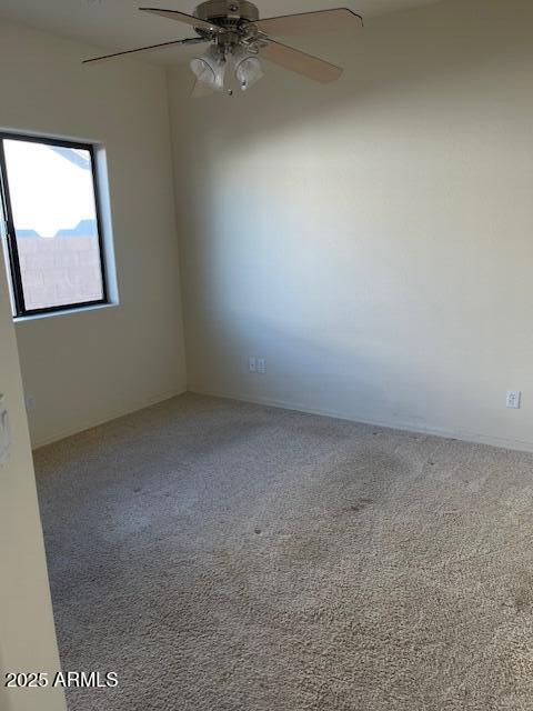 spare room with carpet flooring and a ceiling fan