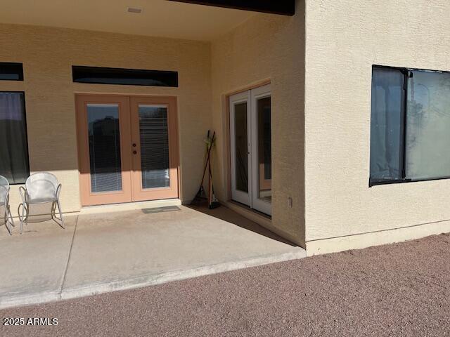 view of exterior entry featuring a patio, french doors, and stucco siding