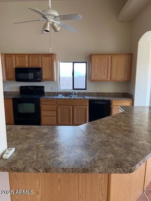 kitchen featuring a ceiling fan, a high ceiling, arched walkways, a sink, and black appliances