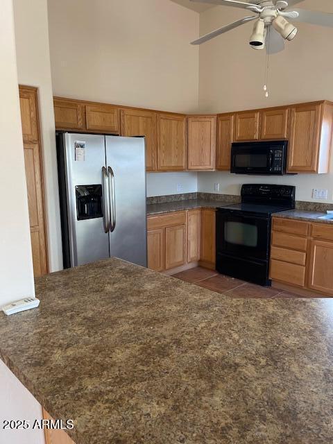 kitchen with light tile patterned floors, high vaulted ceiling, black appliances, and a ceiling fan