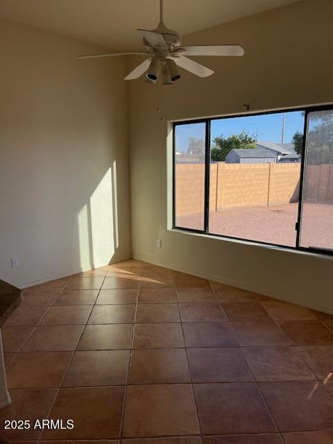 tiled spare room with a ceiling fan