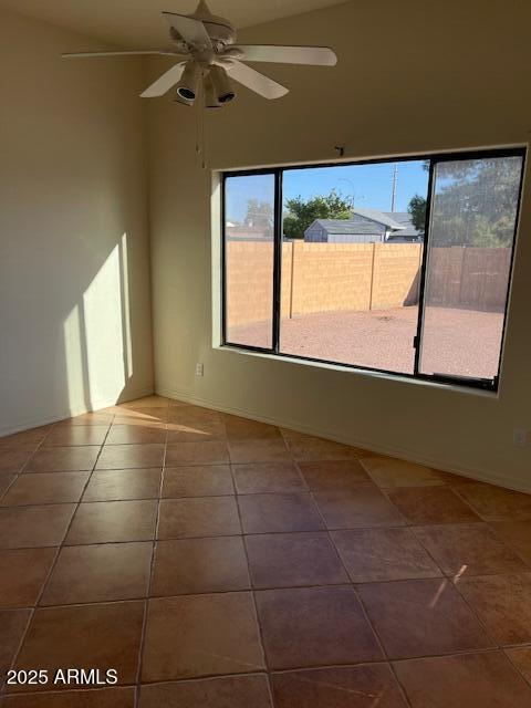 spare room with a ceiling fan and tile patterned flooring