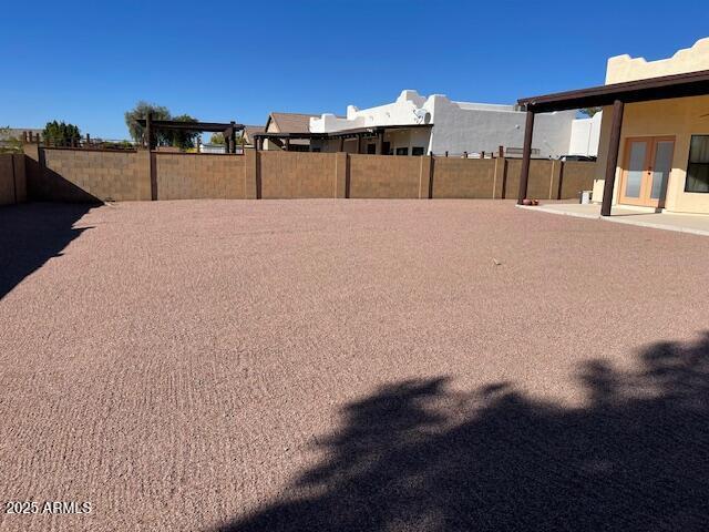 view of yard featuring french doors and fence