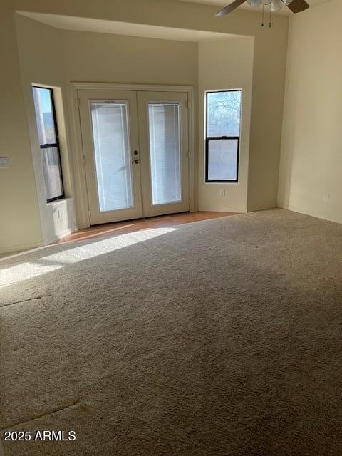 carpeted spare room with french doors and ceiling fan