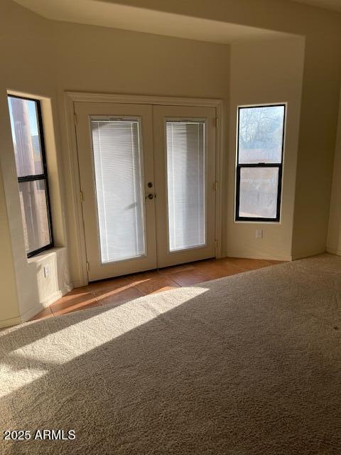 interior space featuring french doors and light carpet