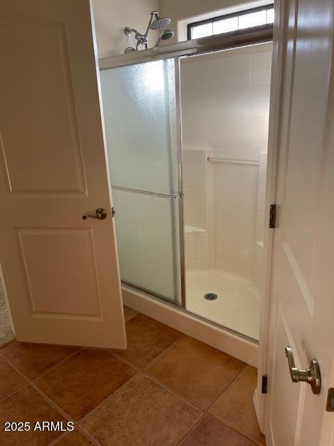 full bathroom featuring tile patterned floors and a shower stall