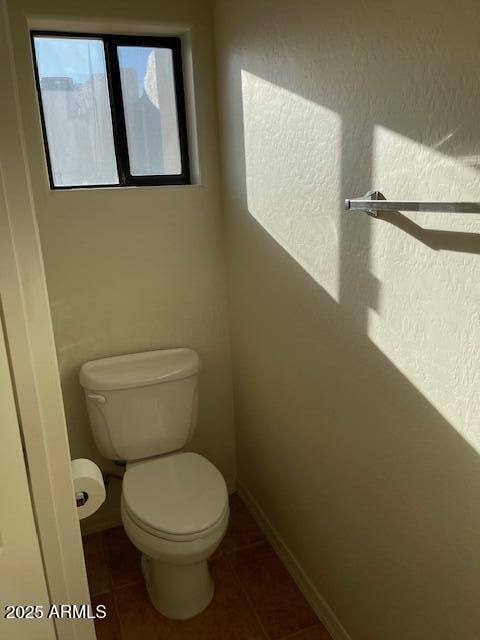 bathroom featuring tile patterned floors, baseboards, and toilet