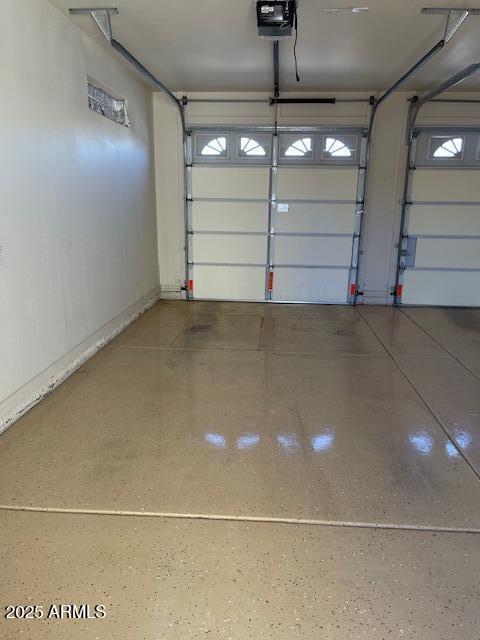 garage with a garage door opener and baseboards