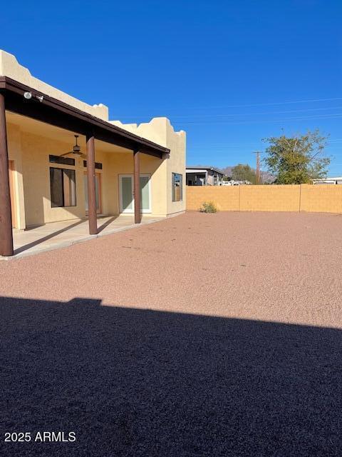 view of yard featuring a fenced backyard, ceiling fan, and a patio area