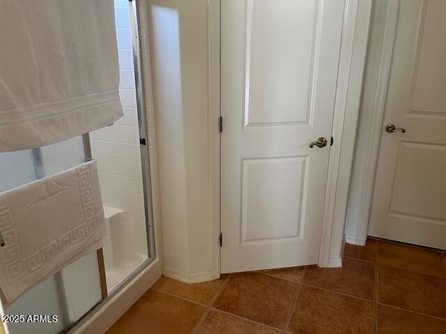 bathroom with walk in shower and tile patterned flooring