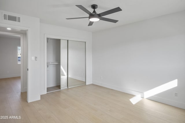 unfurnished bedroom with a closet, ceiling fan, and light wood-type flooring