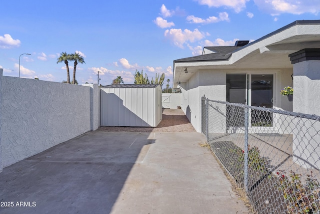 view of property exterior featuring a storage shed and a patio area