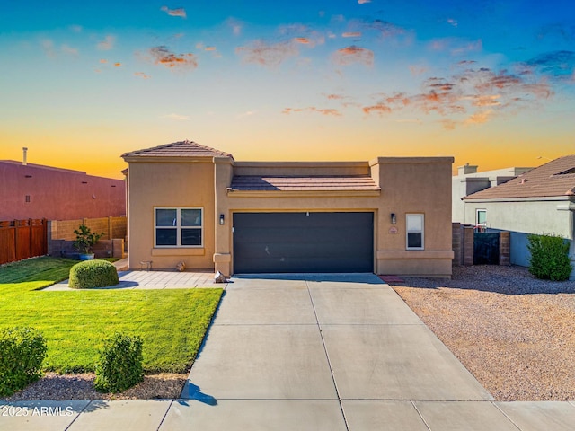 view of front of property with concrete driveway, an attached garage, stucco siding, and fence
