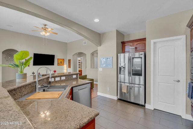 kitchen with a sink, visible vents, arched walkways, ceiling fan, and appliances with stainless steel finishes