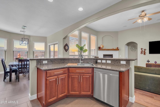 kitchen with a center island with sink, open floor plan, a sink, and dishwasher