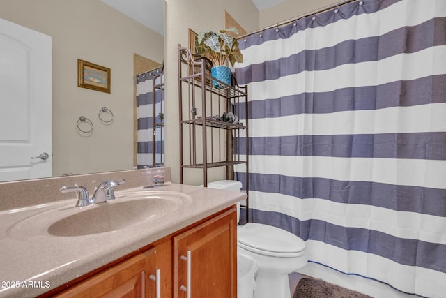 bathroom with toilet, vanity, and curtained shower