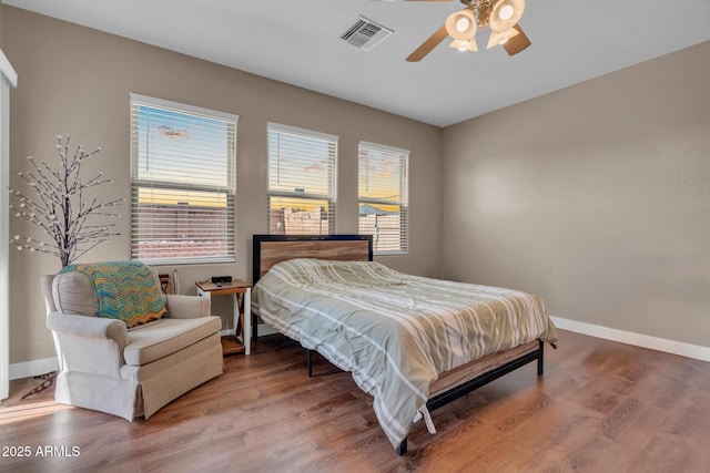 bedroom featuring multiple windows, visible vents, and wood finished floors