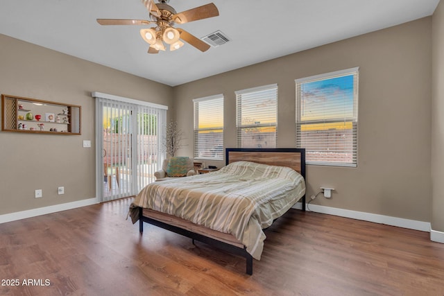 bedroom with access to outside, baseboards, visible vents, and wood finished floors