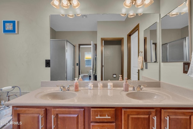 full bath with a shower stall, visible vents, double vanity, and a sink
