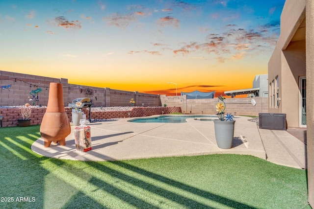 pool at dusk with a fenced backyard, a patio, a fenced in pool, and a yard