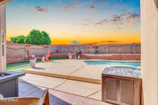 pool at dusk with a fenced backyard, a patio area, and a fenced in pool