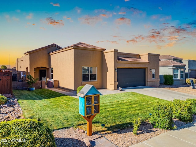 view of front of house featuring a lawn, stucco siding, driveway, and a garage