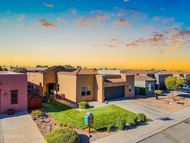 view of front of house with driveway, stucco siding, a tile roof, and a garage