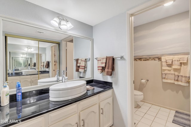 bathroom featuring vanity, toilet, and tile patterned flooring