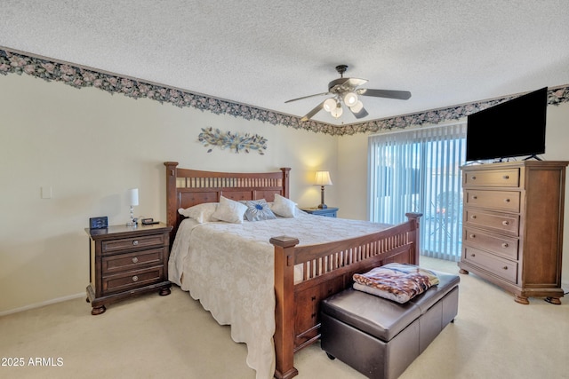 bedroom with ceiling fan, light colored carpet, and a textured ceiling