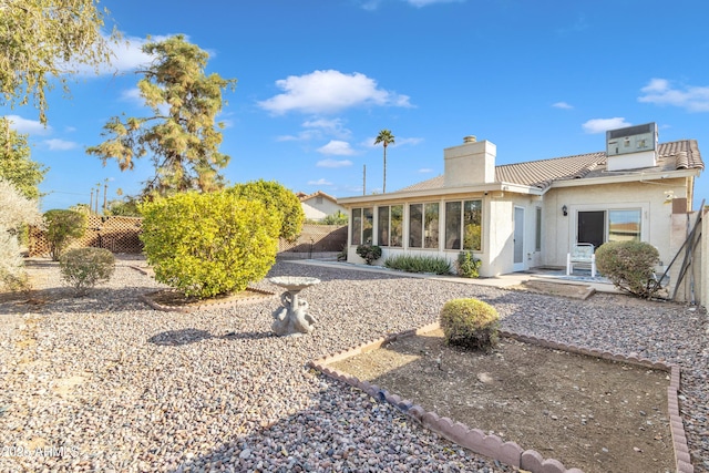 rear view of house with a patio area and a sunroom