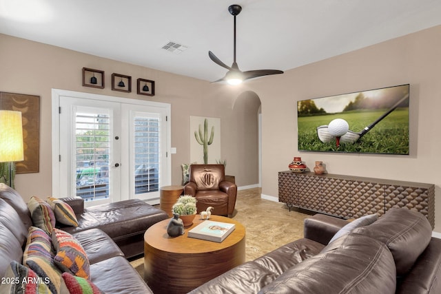 living area with visible vents, arched walkways, baseboards, ceiling fan, and french doors