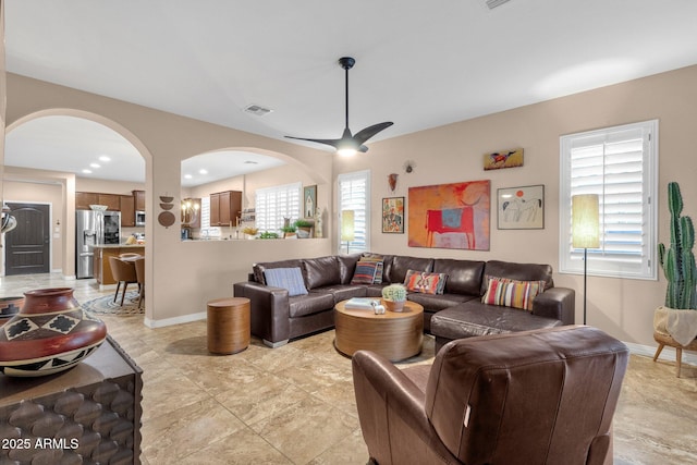 living room featuring ceiling fan and baseboards