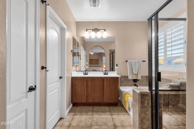 bathroom featuring visible vents, a sink, and a shower stall