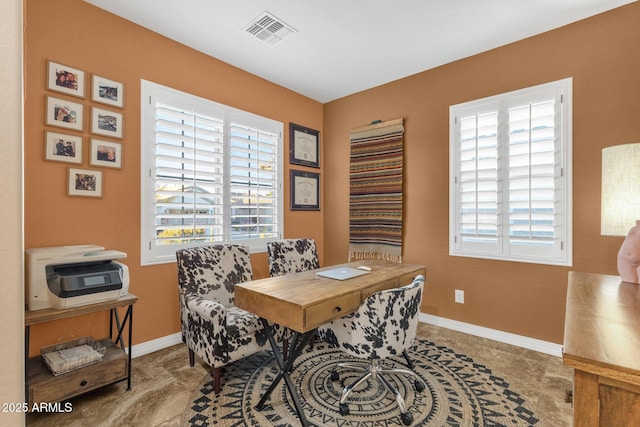 office space with baseboards, visible vents, and a wealth of natural light