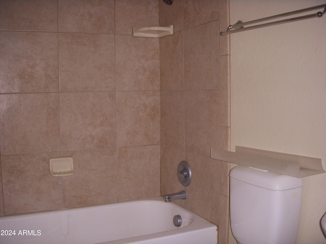 bathroom with toilet and tiled shower / bath