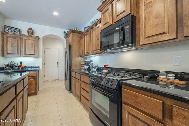 kitchen with arched walkways, light tile patterned floors, recessed lighting, black appliances, and brown cabinetry