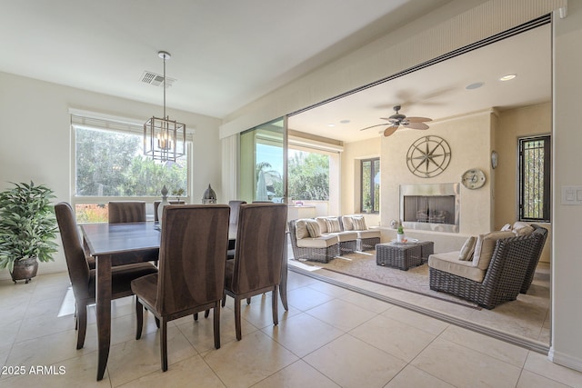 dining area with light tile patterned flooring, plenty of natural light, a high end fireplace, and visible vents