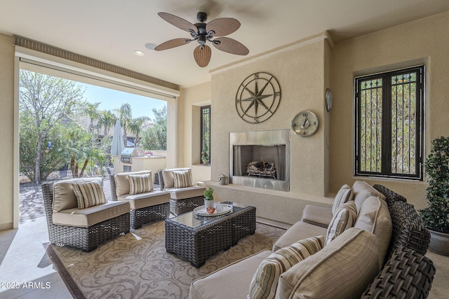 living area with a premium fireplace and a ceiling fan