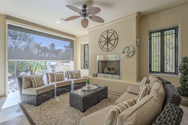 living room featuring plenty of natural light, a fireplace, and ceiling fan